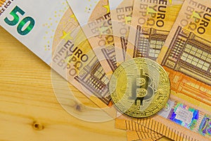 Golden Bitcoins close-up on euro currency background. High resolution photo
