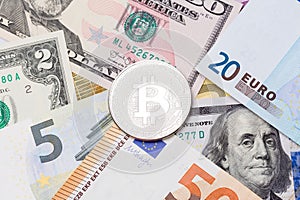 Golden Bitcoins close-up. Euro and dollars currency as a background.
