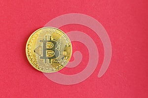 Golden Bitcoins digital virtual money on red background. copy space