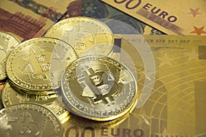 Golden bitcoins on euro banknotes, closee up