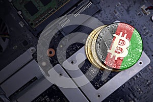 Golden bitcoins with flag of afghanistan on a computer electronic circuit board. bitcoin mining concept