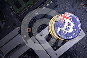 Golden bitcoins with flag of australia on a computer electronic circuit board. bitcoin mining concept