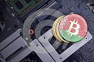 Golden bitcoins with flag of belarus on a computer electronic circuit board. bitcoin mining concept