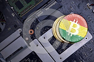 Golden bitcoins with flag of bolivia on a computer electronic circuit board. bitcoin mining concept