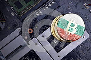 Golden bitcoins with flag of bulgaria on a computer electronic circuit board. bitcoin mining concept
