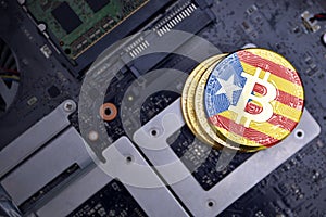 Golden bitcoins with flag of catalonia on a computer electronic circuit board. bitcoin mining concept