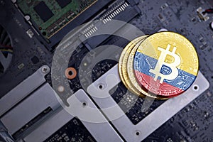 Golden bitcoins with flag of colombia on a computer electronic circuit board. bitcoin mining concept