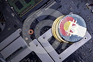 Golden bitcoins with flag of colorado state on a computer electronic circuit board. bitcoin mining concept