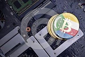 Golden bitcoins with flag of comoros on a computer electronic circuit board. bitcoin mining concept