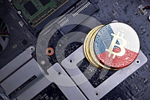 Golden bitcoins with flag of czech republic on a computer electronic circuit board. bitcoin mining concept