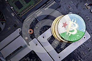 Golden bitcoins with flag of djibouti on a computer electronic circuit board. bitcoin mining concept