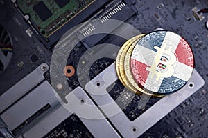 Golden bitcoins with flag of dominican republic on a computer electronic circuit board. bitcoin mining concept