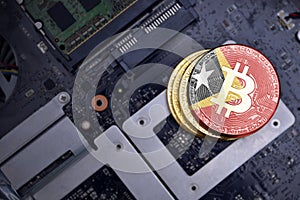 Golden bitcoins with flag of east timor on a computer electronic circuit board. bitcoin mining concept