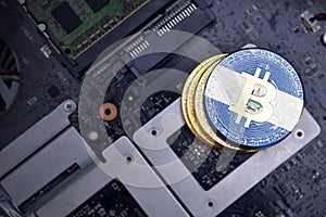 Golden bitcoins with flag of el salvador on a computer electronic circuit board. bitcoin mining concept