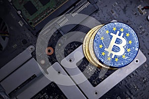 Golden bitcoins with flag of european union on a computer electronic circuit board. bitcoin mining concept