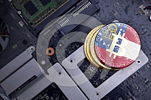 Golden bitcoins with flag of georgia state on a computer electronic circuit board. bitcoin mining concept