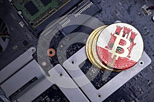 Golden bitcoins with flag of gibraltar on a computer electronic circuit board. bitcoin mining concept