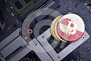 Golden bitcoins with flag of greenland on a computer electronic circuit board. bitcoin mining concept