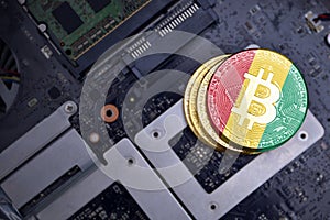 Golden bitcoins with flag of guinea on a computer electronic circuit board. bitcoin mining concept