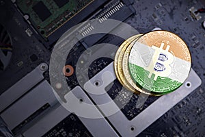 Golden bitcoins with flag of india on a computer electronic circuit board. bitcoin mining concept
