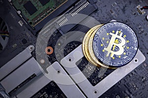 Golden bitcoins with flag of indiana state on a computer electronic circuit board. bitcoin mining concept