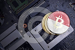 Golden bitcoins with flag of indonesia on a computer electronic circuit board. bitcoin mining concept