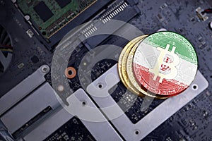 Golden bitcoins with flag of iran on a computer electronic circuit board. bitcoin mining concept