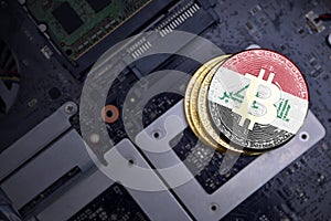 Golden bitcoins with flag of iraq on a computer electronic circuit board. bitcoin mining concept