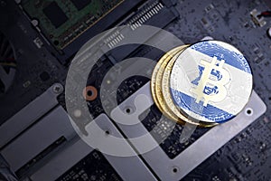 Golden bitcoins with flag of israel on a computer electronic circuit board. bitcoin mining concept