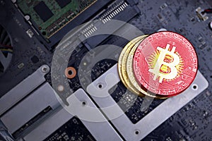 Golden bitcoins with flag of kyrgyzstan on a computer electronic circuit board. bitcoin mining concept