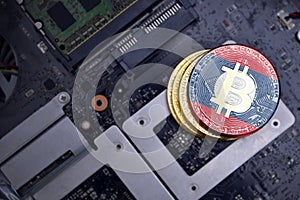 Golden bitcoins with flag of laos on a computer electronic circuit board. bitcoin mining concept
