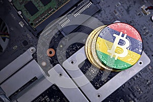 Golden bitcoins with flag of mauritius on a computer electronic circuit board. bitcoin mining concept