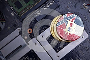 Golden bitcoins with flag of mississippi state on a computer electronic circuit board. bitcoin mining concept