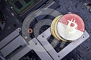 Golden bitcoins with flag of monaco on a computer electronic circuit board. bitcoin mining concept