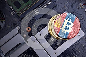 Golden bitcoins with flag of mongolia on a computer electronic circuit board. bitcoin mining concept