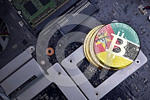 Golden bitcoins with flag of mozambique on a computer electronic circuit board. bitcoin mining concept