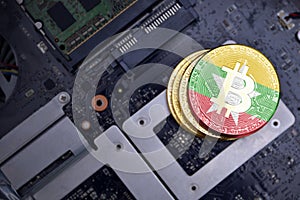 Golden bitcoins with flag of myanmar on a computer electronic circuit board. bitcoin mining concept