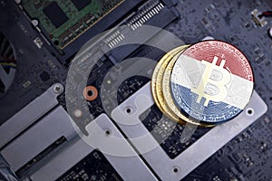 Golden bitcoins with flag of netherlands on a computer electronic circuit board. bitcoin mining concept