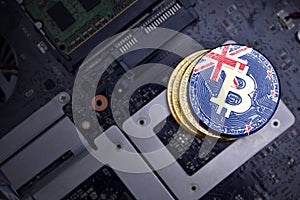 Golden bitcoins with flag of new zealand on a computer electronic circuit board. bitcoin mining concept