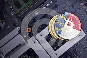 Golden bitcoins with flag of north carolina state on a computer electronic circuit board. bitcoin mining concept