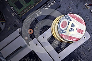 Golden bitcoins with flag of ohio state on a computer electronic circuit board. bitcoin mining concept