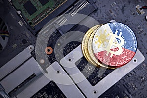 Golden bitcoins with flag of philippines on a computer electronic circuit board. bitcoin mining concept