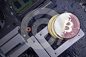 Golden bitcoins with flag of qatar on a computer electronic circuit board. bitcoin mining concept