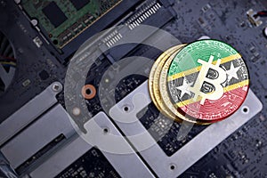 Golden bitcoins with flag of saint kitts and nevis on a computer electronic circuit board. bitcoin mining concept