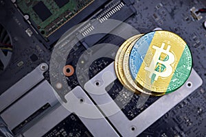 Golden bitcoins with flag of saint vincent and the grenadines on a computer electronic circuit board. bitcoin mining concept