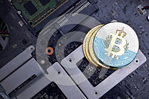 Golden bitcoins with flag of san marino on a computer electronic circuit board. bitcoin mining concept