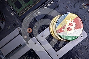 Golden bitcoins with flag of seychelles on a computer electronic circuit board. bitcoin mining concept