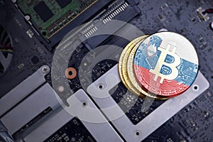 Golden bitcoins with flag of slovenia on a computer electronic circuit board. bitcoin mining concept