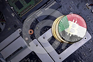 Golden bitcoins with flag of sudan on a computer electronic circuit board. bitcoin mining concept