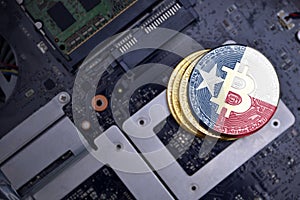 Golden bitcoins with flag of texas state on a computer electronic circuit board. bitcoin mining concept